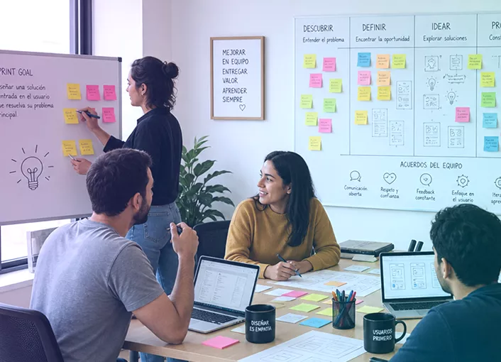 Diseñadora señalando un tablero con notas adhesivas