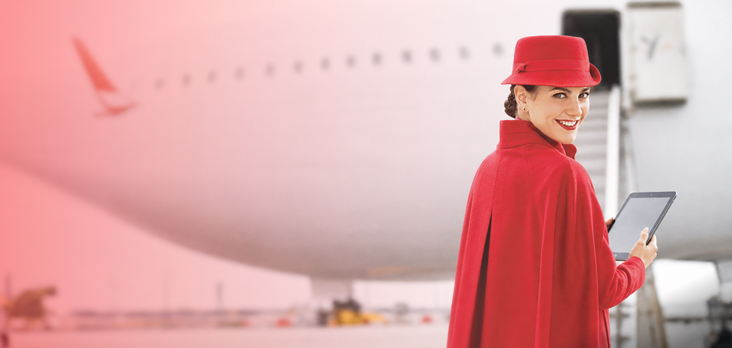 Colaboradora de Avianca con uniforme rojo utilizando una tableta